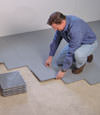 Contractors installing basement sub floor tiles and matting on a concrete basement floor in Bay Shore, Long Island