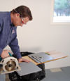installing a waterproof vapor barrier on a basement floor to prepare for basement carpeting in a Rockville Centre home